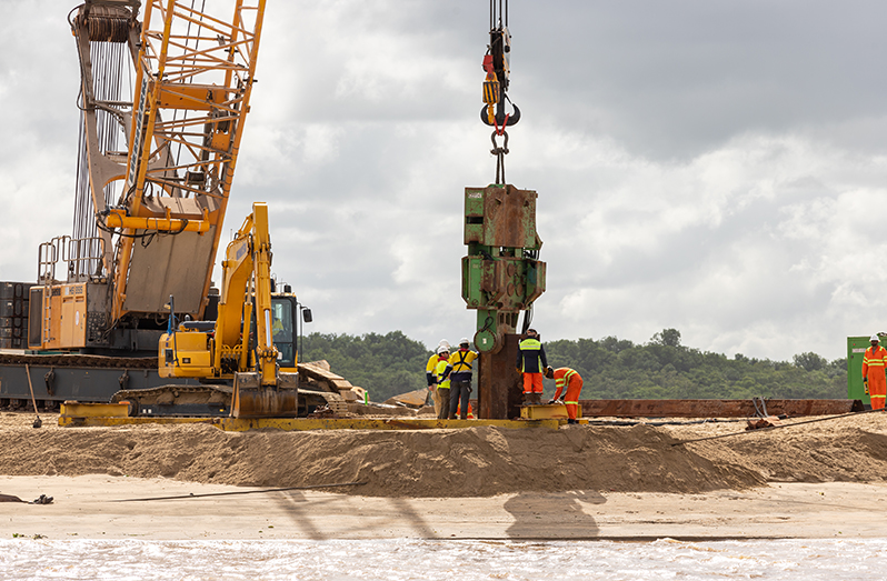 Workers on the Vreed-en-Hoop Shore Base Inc. driving the first set of sheet piles, which marks the start of the quay wall installation