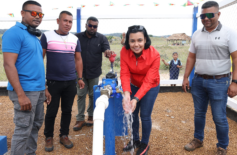 Minister within the Ministry of Housing and Water Susan Rodrigues testing the water supply at the newly commissioned $26.5M water supply system in Taruka, Region Eight