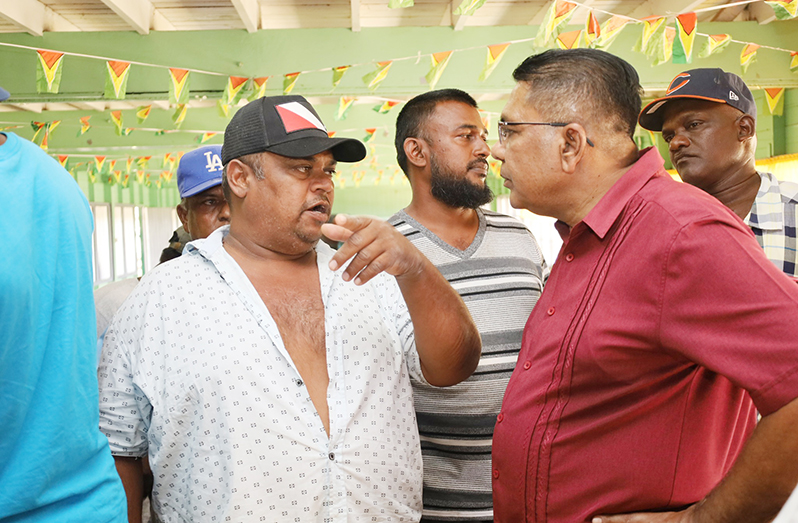 Minister of Agriculture, Zulfikar Mustapha (right), engages a farmer during his outreach to Region Six (East Berbice- Corentyne) on Saturday (Ministry of Agriculture photo)