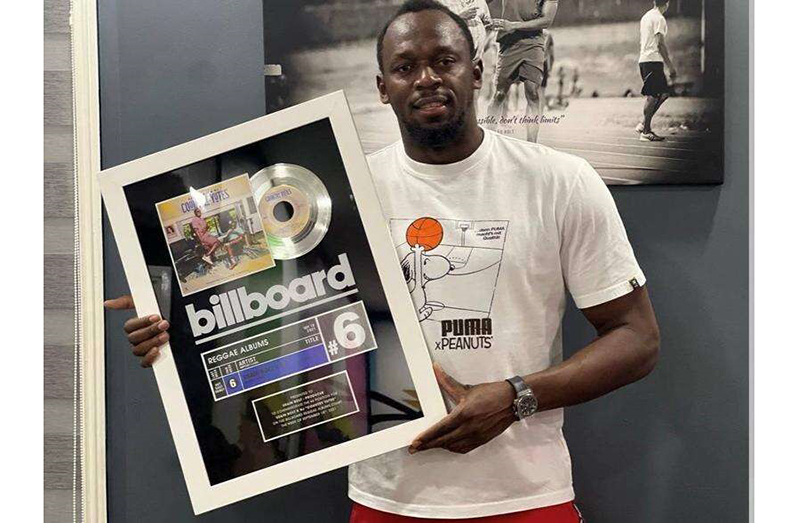Olympian-turned-music producer Usain Bolt displaying his Billboard plaque for Country Yutes