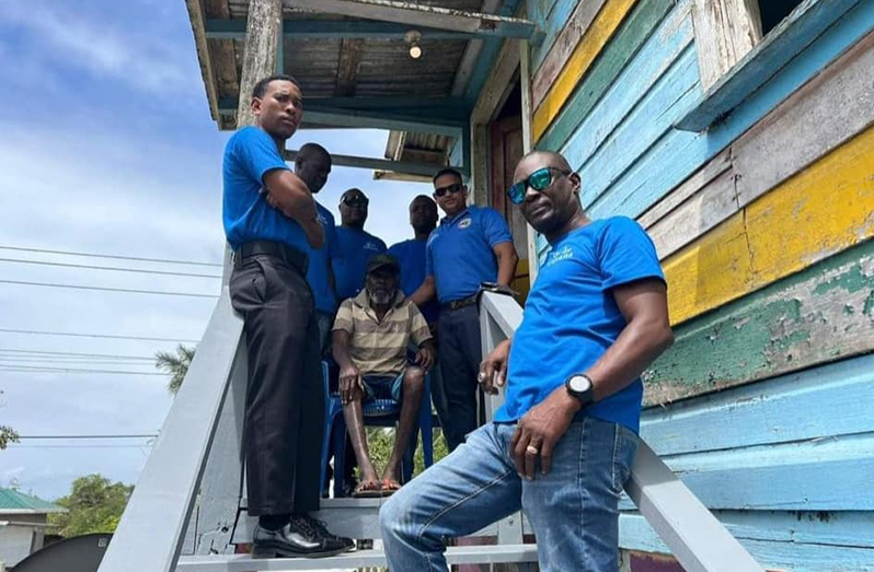 The Men on Mission team with 70-year-old Allan Caleb on his rehabilitated stairway (Guyana Police Force photo)
