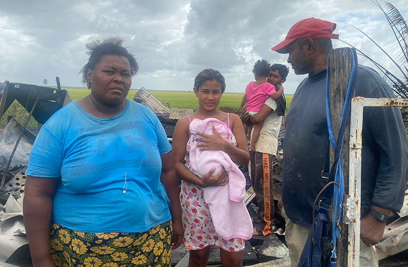Tracy Devellier and her family at the site where their house stood at Cotton Field on the Essequibo Coast