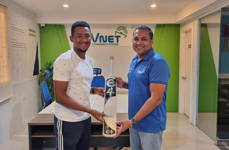 Chief Executive Officer Safraz Sheriffudeen (right) hands over the new bat to Kemol Savory.
