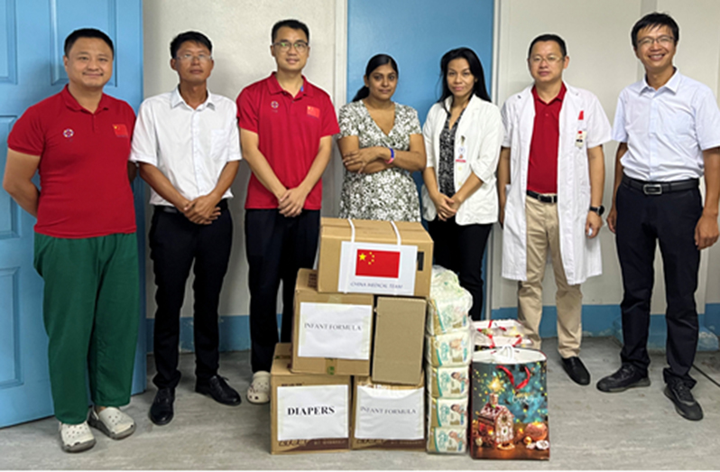 Obstetrics and Gynaecology consultant, Dr. Jiang Yuan (second from right) flanked by members of the 18th Chinese Medical Brigade and officials from the Chinese-funded donor company with the supplies handed over to the mother of the triplets