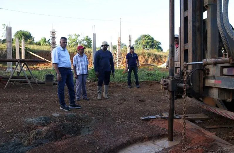 Minister of Housing and Water Collin Croal examines the new well at Khan’s Hill, Region One
