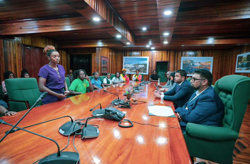 H.E. Dr. Mohamed Irfaan Ali, (right) listens intently to the concerns of one of Guyana’s national athletes (Office of the President photo)