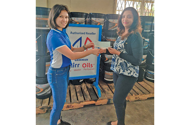 Ms. Sandra Prashad of Yellow Mines Hydraulics (left) hands over contribution to Ms. Fung-A-Fat.