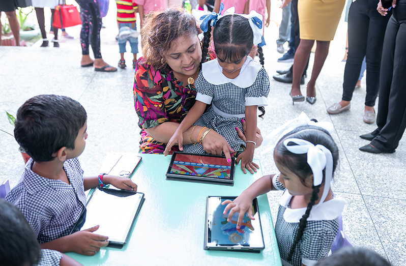 Minister of Education, Priya Manickchand and nursery school children engaging the Animal Friends Learning App