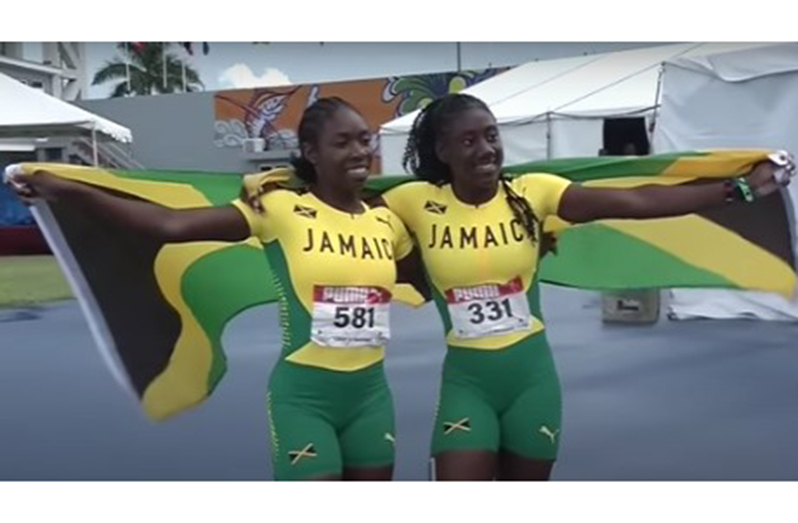 Alexis James (right) and teammate Asharria Ulette celebrate their Jamaica one-two in the girls’ Under-20 sprint hurdles.