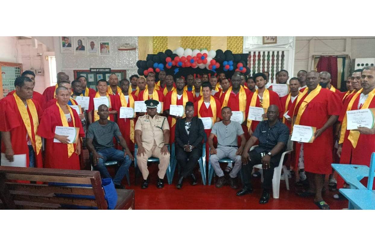 Officer-in-Charge of Mazaruni prison, Superintendent of Prisons, David Shepherd (seated second from left) flanked by other officials with the inmates that graduated in various trade skills