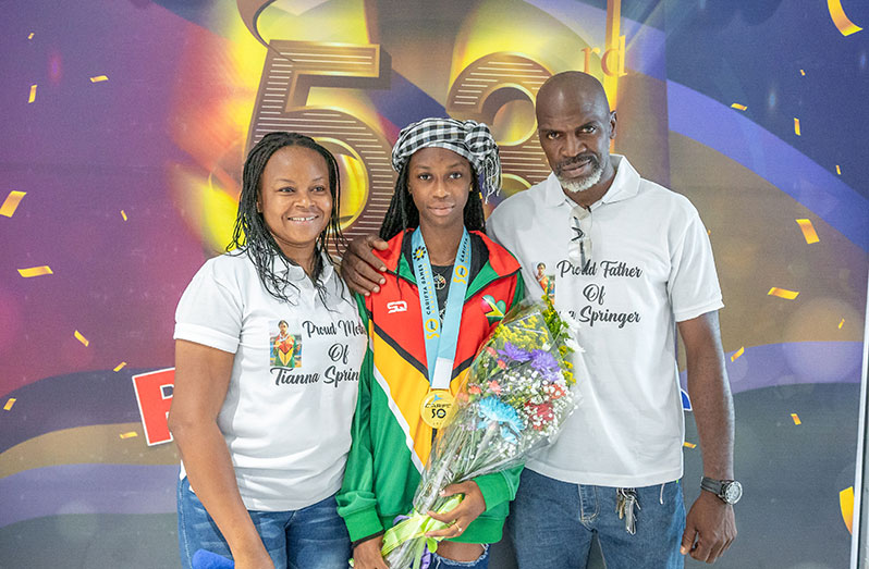 Flashback, Tiana Spinger (center) and her parents after arriving home for the 2023 Carifta Games.