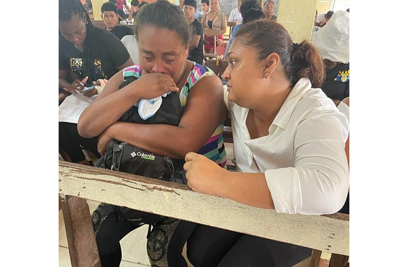 Minister of Education Priya Manickchand consoles Valerie Carter, mother of 15-year-old twins Mary and Martha D’Andrade, who are among those who died (Ministry of Education photos)