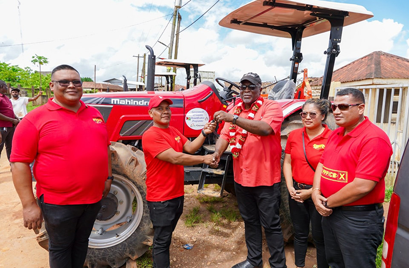 Prime Minister, Brigadier (Ret’d) Mark Phillips hands over the keys to one of the many tractors that will expand agriculture production and beautification projects in Matarkai sub-district. Looking on are Minister of Housing and Water Collin Croal and Regional Chairman Brentnol Ashley