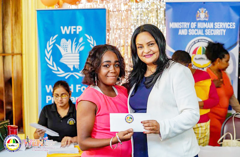 Dr. Vindhya Persaud, Minister of Human Services and Social Security, presents a cash grant to a participant