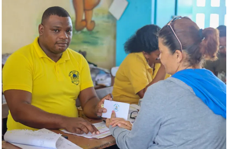 A parent receives the ‘Because We Care’ cash grant and uniform/supplies voucher