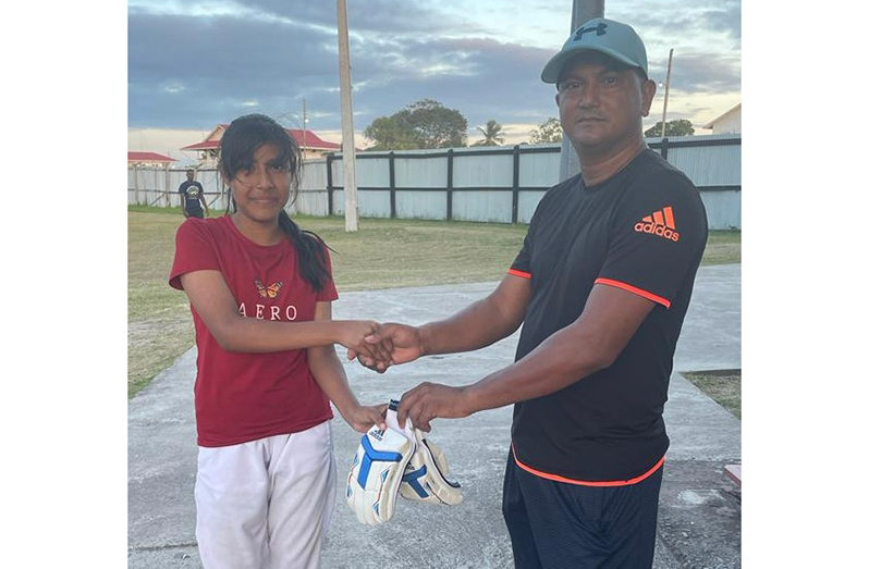 Jade Campbell (left) collects her gear from Balram Samaroo who presented on behalf of the project