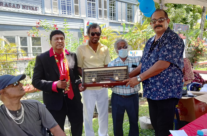 Charismatic media personality Frederick Rampersaud with one of his fans who brought a working Phillips brand radio through which he listened to Rampersaud’s voice over 20 years. Also holding the radio is R3PSInc Head, Halim Khan (centre), along with an NTN official