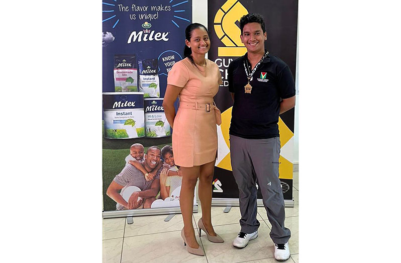 Ethan Lee receives his prize from Ms. Alicia De Abreu, CEO of De Sinco Ltd