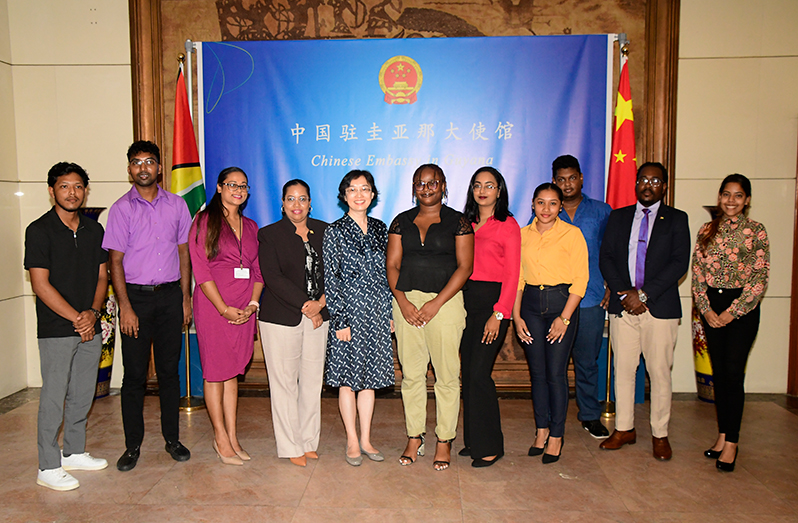 Chinese Ambassador to Guyana Guo Haiyan, (fifth from left), the Public Service Ministry’s Scholarships Manager, Deomattie Seeram (third from left), Ansel Campbell (extreme left), Shameeza Baksh (extreme right), other officials, and students who were awarded scholarships to study in China (Adrian Narine photo)