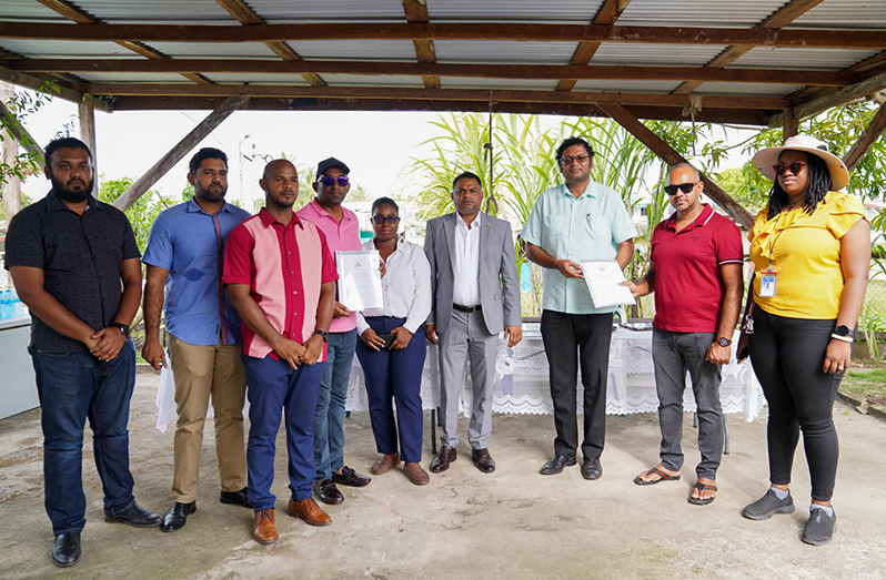 Minister within the Ministry of Public Works Deodat Indar and Permanent Secretary Vladim Persaud issue the agreement to the contractors for rehabilitation of Factory Road, Enterprise, ECD
