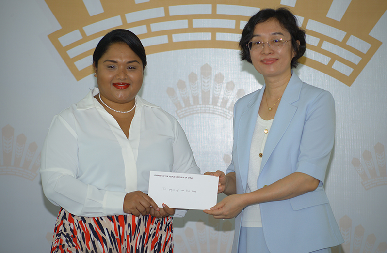 Ambassador of China to Guyana Guo Haiyan (right) handing over a cheque to First Lady Arya Ali (left) on Wednesday in support of the initiatives undertaken by her office (Japheth Savory photo)