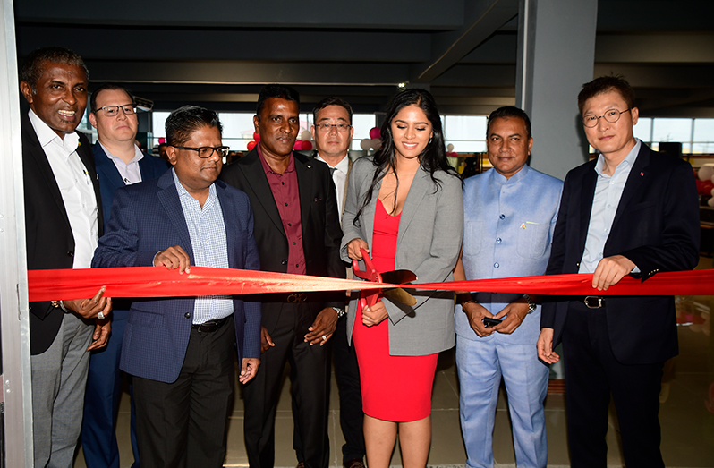 Minister Ashni Singh (second from left) and Dr. Aliesha Wahab, CFO of LG Guyana, cutting the ribbon in the presence of other officials and company executives at the LG’s launch (Adrian Narine photo)