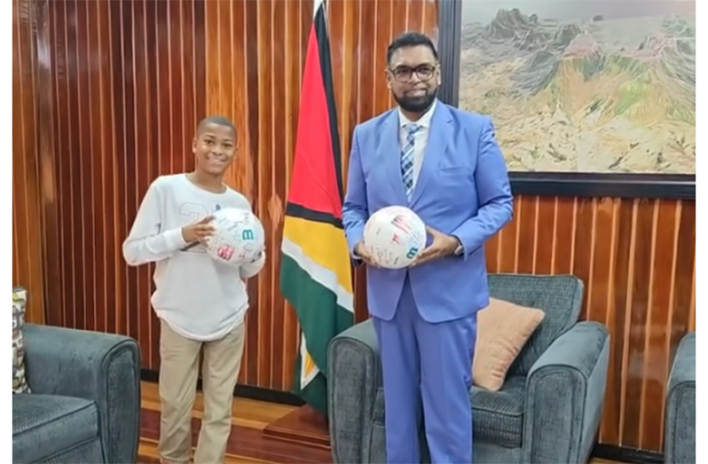 President Irfaan Ali and Ismachiah Oduwole holding the signed climate balls