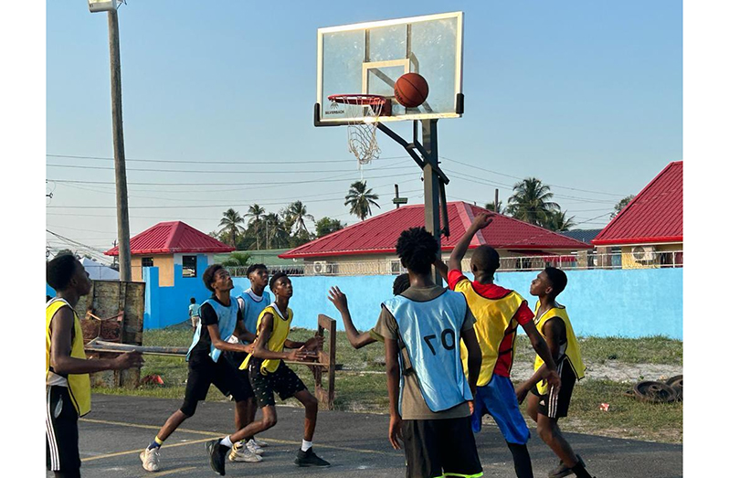 Action in the Schools basketball New Silvercity Secondary in yellow bibs versus Harmony Secondary in light blue bibs