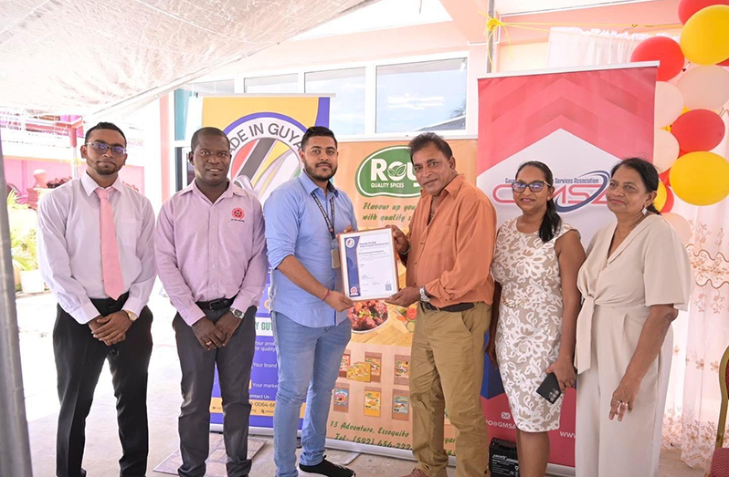 General Manager, Lakiraj ‘Roy’ Singh (third from right), receives the ‘Made in Guyana’ Certification