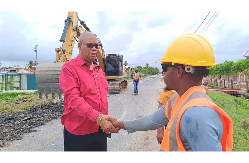 Minister of Public Works, Juan Edghill, interacting with a worker while visiting one of the ongoing road projects in June 2023