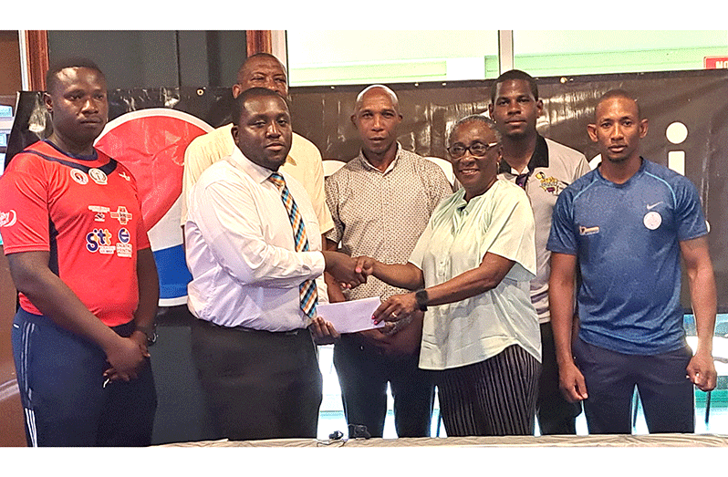 Watched by members of the GCA.  DDL’s Rodney Ambrose hands over the sponsorship cheque to GCA’s Debbie McNichols on Thursday at Everest (Sean Devers photo)