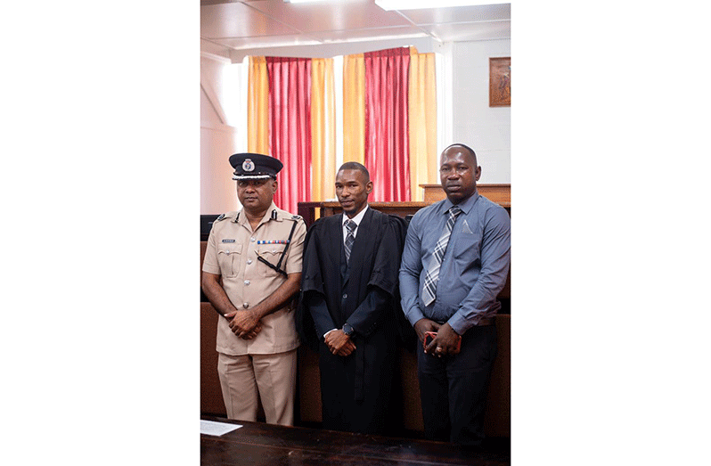 Attorney-at-law Rayon Doris (centre) flanked by his biological father Troy Doris and Deputy ‘Operations’ (ag.), Ravindradat Budhram (at left) whom he also acknowledges as a father figure