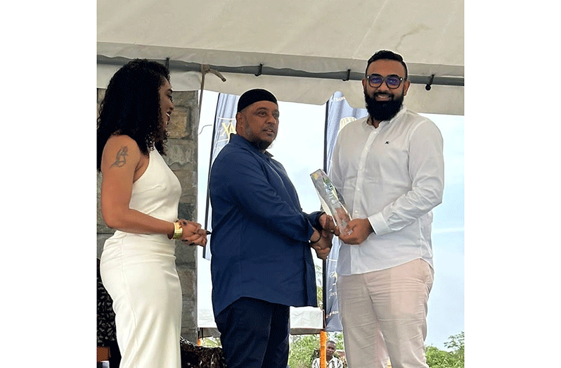 Proprietor of the Sheriff Group of Companies, Ameir Ahmad, accepting his award from a representative of the Berbice Chamber of Commerce