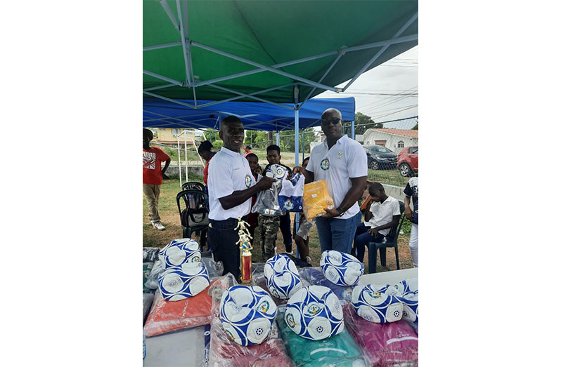 President of the East Bank Football Association, Orien Angoy (left) receives equipment on behalf of Diamond United FC from Franklin Wilson.