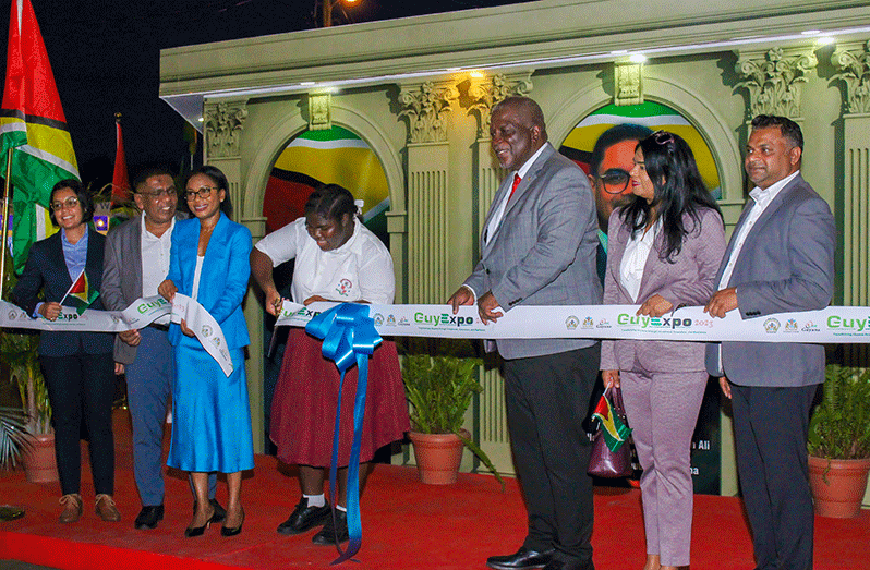 Prime Minister, Brigadier (Ret’d), Mark Phillips, Minister of Tourism, Oneidge Walrond and other government officials assist a student to cut the ribbon to official open GuyExpo 2023 (Shaniece Bamfield photos)