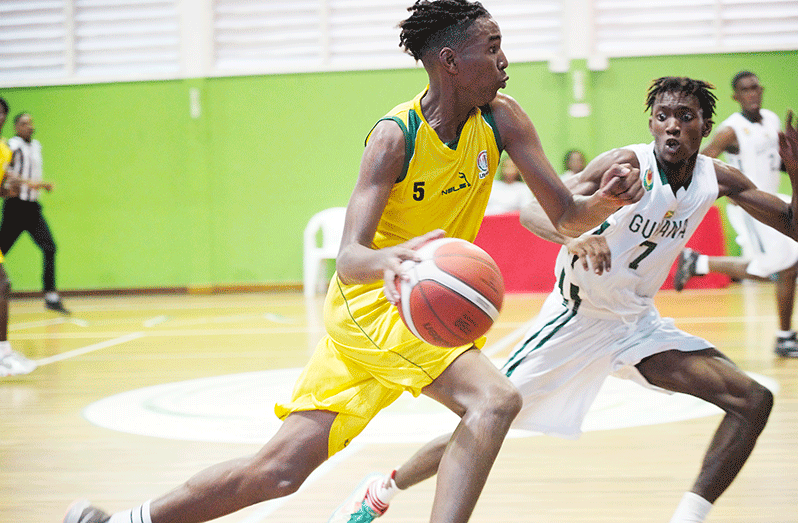 Guyana's Ezekiel Saul (right) marks Hingile Laurent of French Guiana (Calvin Chapman photo)