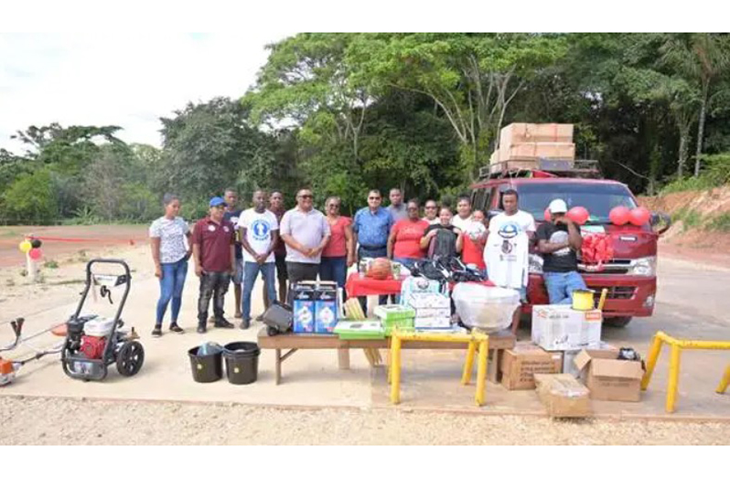 Minister of Housing and Water Collin Croal handing over the bus and other items to the community