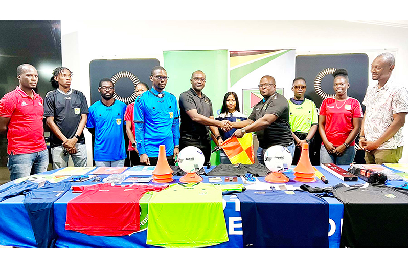 GFF President Wayne Forde (centre) makes the presentation to referees