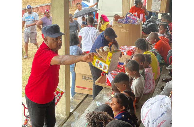 Deputy Commissioner 'Operations' (ag), Ravindradat Budhram in one of the many scenes that brought smiles to the faces of children who received unexpected Christmas gifts