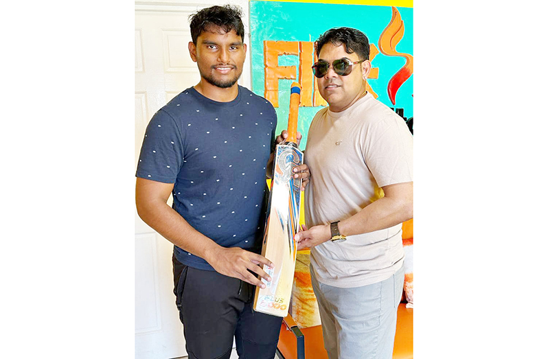 Vishal Nagamootoo (left) hands over the bat to Aaron Beharry.