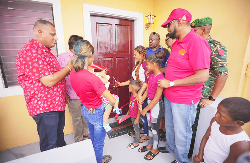 The Berbice mother cuts the symbolic red ribbon to enter her new, furnished home on Christmas Day