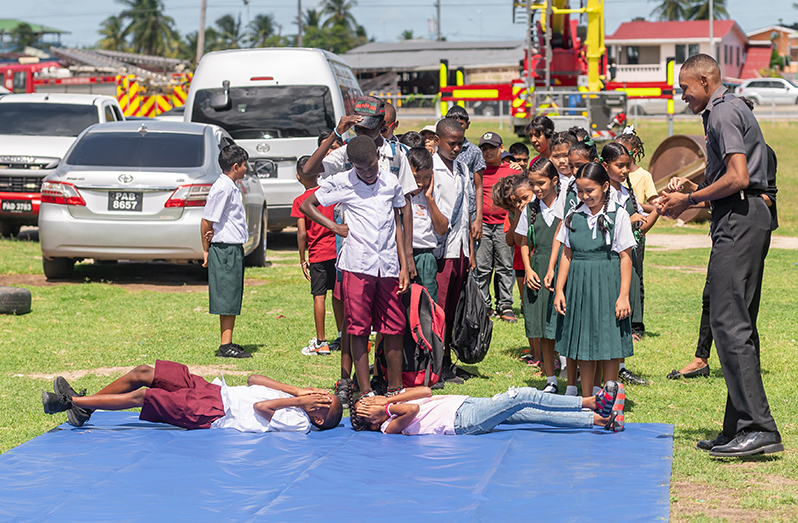 Children taking part in the stop, drop and roll demonstration at the Kids Camp