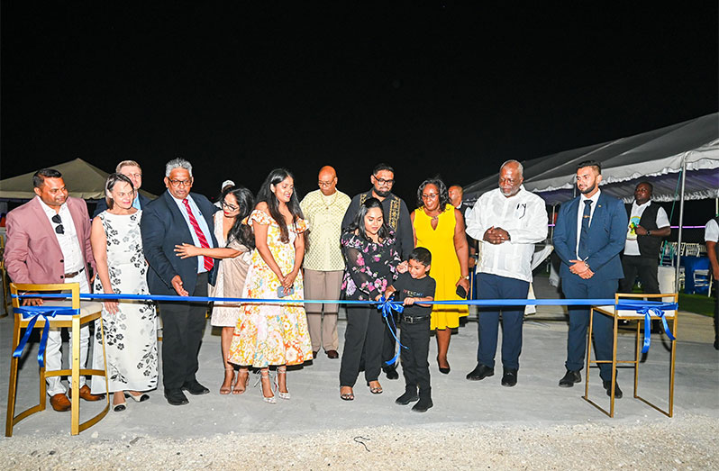 First Son, Zayd, cuts the ribbon to commission the marine facility while First Lady, Mrs. Arya Ali; President Dr Irfaan Ali, the Singhs family and other officials look on