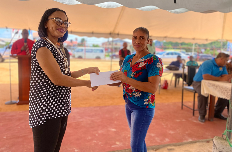 Minister of Tourism, Industry and Commerce Oneidge Walrond hands over a cheque to one of the recipients