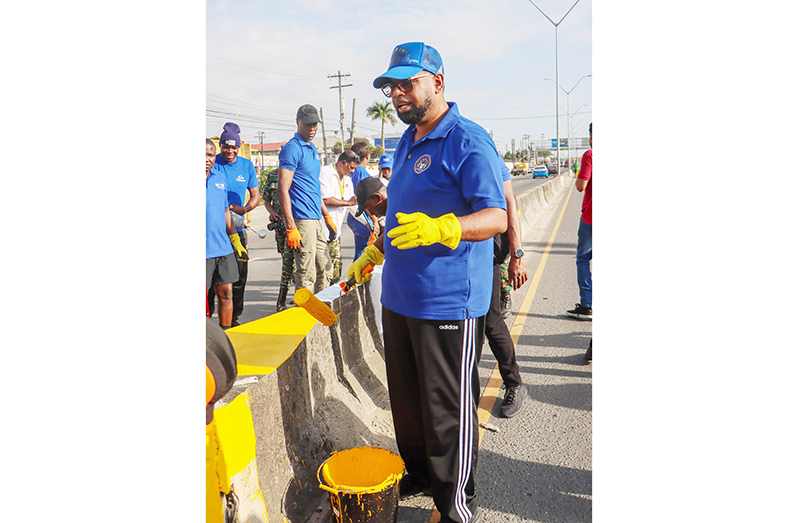 President Dr Irfaan Ali repainting the median along the Agricola Public Road (Photos by Japheth Savory; Guyana Police Force and DPI)
