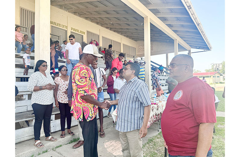 Minister Singh interacts with resident Quacy Henry. Pictured at right is Regional Executive Officer Narindra Persaud