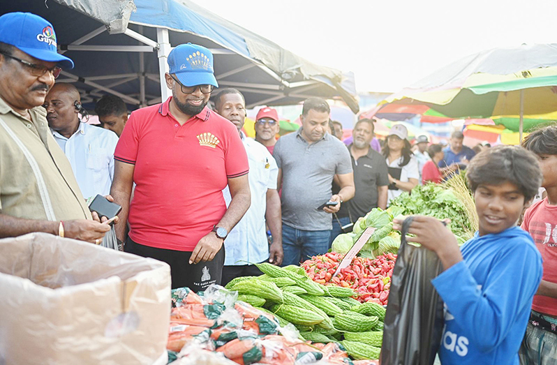President Dr. Irfaan Ali interacts with a child at the Leonora Market on Saturday