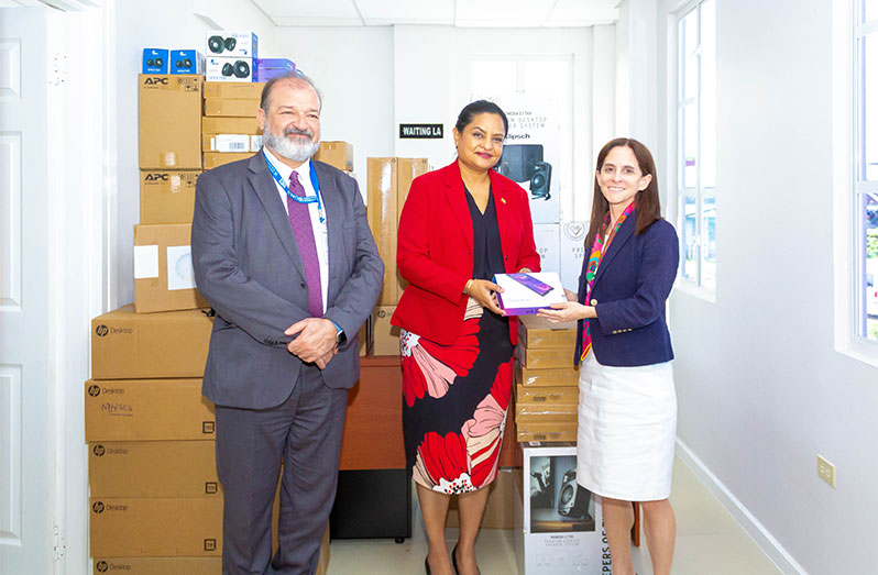 Minister of Human Services and Social Security Dr. Vindhya Persaud (centre) is flanked by UNDP’s Resident Representative for Guyana and Suriname, Gerardo Noto (left) and Deputy Director of UNDP in Latin America and the Caribbean, Linda Maguire. Some of the IT equipment that was given to the government is behind them