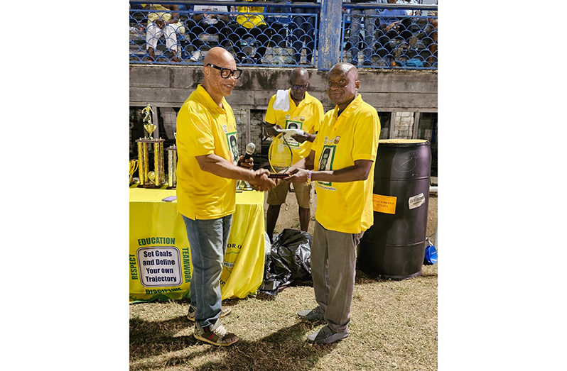 Pele FC Alumni Treasurer Patrick ‘Labba’ Barton presenting the commemorative plaque to Dr. Colin Watson. In the foreground is Erick ‘Riggy’ Smith