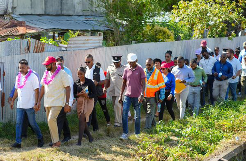 President Dr. Mohamed Irfaan Ali, the Minister within the Ministry of Public Works, Deodat Indar, other cabinet members, and residents of Uitvlugt, during the President’s visit last year
 